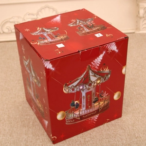 Close-up of a red Christmas carousel music box gift packaging with festive illustrations