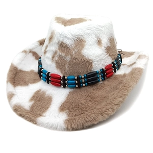 Brown and white cow print western cowboy hat with ethnic beaded band on white background