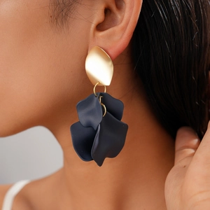 Close-up of model wearing unique acrylic gold and deep blue irregular floral drop earrings