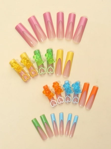 Primer plano de uñas postizas de colores con ositos 3D y decoraciones de corazones