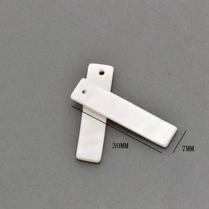 Macro shot of 30x7mm rectangular natural white shell charms with pre-drilled holes