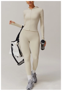 Detail of beige yoga set featuring a hooded zip-up jacket with thumbholes and leggings