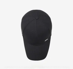 Top view of black cotton baseball cap showing detailed six-panel structure and metal logo