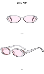Close-up of retro oval sunglasses with transparent grey frames and pink tinted lenses
