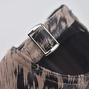 Detail of leopard print baseball cap featuring silver metal buckle and white stitching