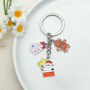Christmas keychain with Santa Claus, Gingerbread Man, and Xmas Tree on white ceramic plate