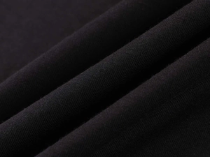 Close-up of premium black cotton fabric texture showing soft draping and fine weave
