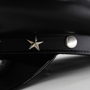 Macro detail of black leather cap with silver star studs and textured litchi grain finish
