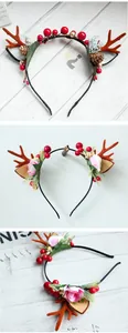 Close-up of reindeer antlers headband with red berries, pine cones and flowers
