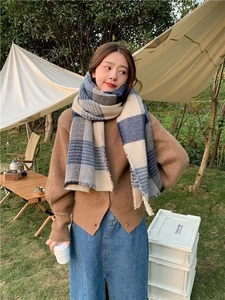 Classic blue plaid scarf on a model in an outdoor camping setting for autumn and winter