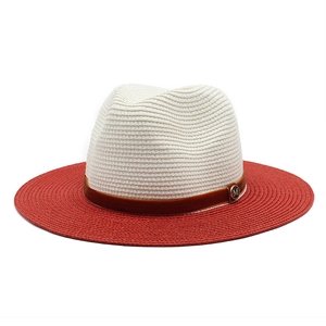 Detailed macro of two-tone woven straw hat with brown suede band and golden M emblem