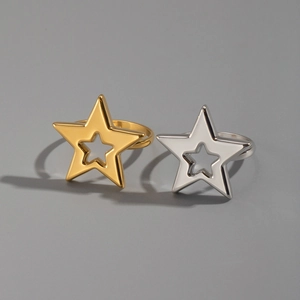 Comparaison de bagues étoiles évidées en or et argent sur fond gris en acier inoxydable