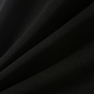 Close-up macro of black textile fabric texture showing fine weave patterns and soft drape