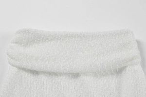 Detail of white high-neck top showing textured bouclé knit fabric and fine stitching