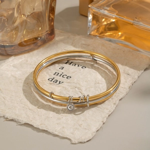 Two-tone gold and silver multi-layer bangle with zircon charms on vintage paper