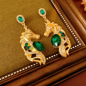 Detailansicht goldener Vintage-Pferdekopf-Ohrringe mit grünen Edelsteinen und Strasssteinen