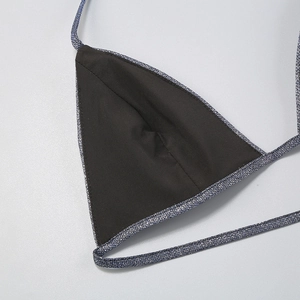 Detail of silver sequin bikini top featuring black lining and tie strap closure