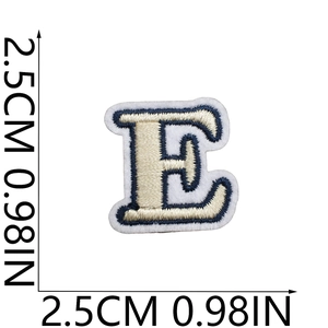 Detailed embroidery texture of small cream and navy letter E patch with 2.5cm size markings