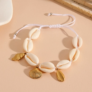 Detail of adjustable beach shell bracelet with golden starfish and conch shell charms