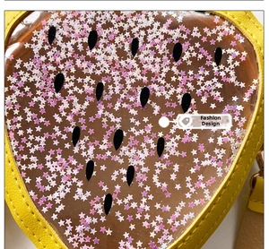 Macro shot of a yellow leather kid's bag featuring a heart-shaped window with star sequins