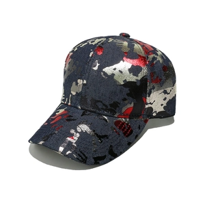 Detail of blue denim baseball cap with metallic red and gold camouflage splatter pattern