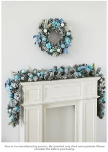 Blue and white Christmas wreath and garland set with snow flocking on a white mantel