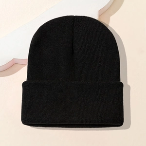 Detail of black knit beanie showing the fine ribbed texture and folded cuff design