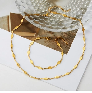 Detail of gold-plated tennis racket style necklace set with mesh textured oval links