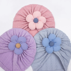 Pink purple and light blue knitted baby hats with large floral detail and cable texture