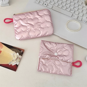 Flat lay of pink quilted heart-shaped storage bags with zipper and snap button