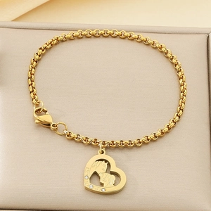 Détail du pendentif cœur doré avec silhouette de cheval et cristaux sur chaîne à maillons