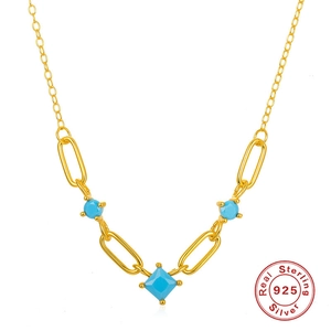 Macro detail of S925 sterling silver gold necklace with turquoise stones and geometric links