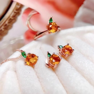 Rose gold jewelry set with orange gemstones and green leaves, featuring ring, necklace, and earrings