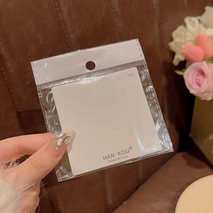 Detailed view of S925 silver pearl bow earrings in branded packaging card display