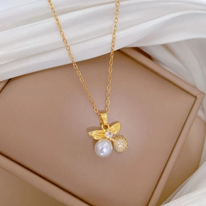 Macro detail of gold necklace pendant with white pearl and crystal on silk backdrop