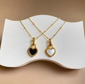 Detailed view of dual-color heart lock pendants in gold finish on beaded chains