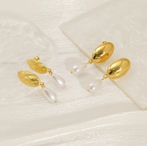 Detail of 18K gold-plated earrings with irregular pearls and elegant leaf-shaped design