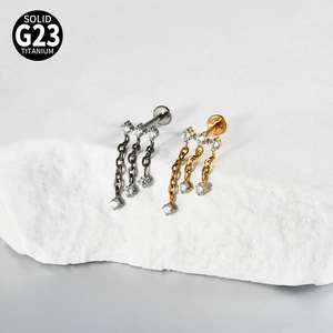 Detail of G23 titanium labret stud with zircon charms and hanging chains on a stone