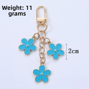 Detail of blue alloy flower keychains with gold edges and dimensions of 2cm diameter