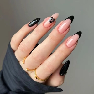 Detailansicht der mandelförmigen Nägel mit schwarzen French Tips und Herzmustern