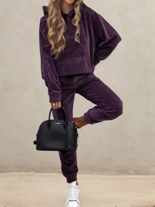 Detail of premium purple velvet tracksuit set featuring a hooded sweatshirt and joggers