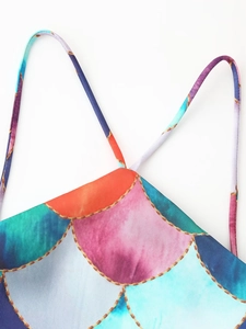 Close-up of halter neck straps with colorful geometric chain print on the dress