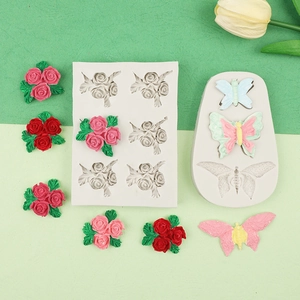 Close-up of flexible silicone molds showing detailed 3D rose flower and butterfly shapes
