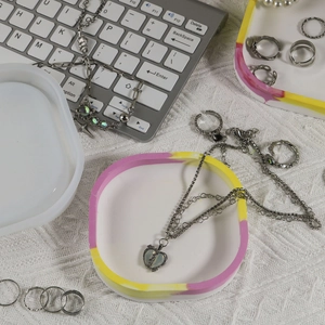 Detailed view of handmade oval resin tray with matching silicone mold and jewelry set