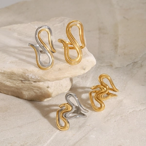Polished titanium steel streamlined rings in gold and silver on a natural stone base