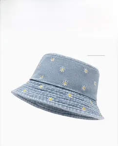 Close-up of light blue denim bucket hat with white and yellow daisy embroidery detail