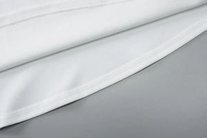 Detailed macro view showing the high-quality double-needle stitching on white dress hem