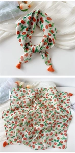 Close-up of ivory cotton linen scarf with red cherry prints and orange corner tassels