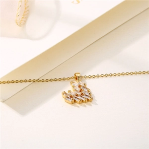 Golden heart pendant necklace with baguette-cut zircons on a minimalist white background