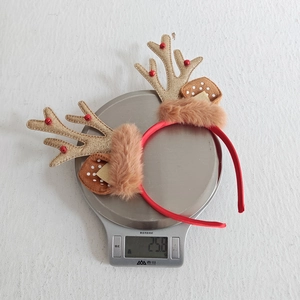 Detail shot of Christmas reindeer headband with gold sequins and brown faux fur on a scale